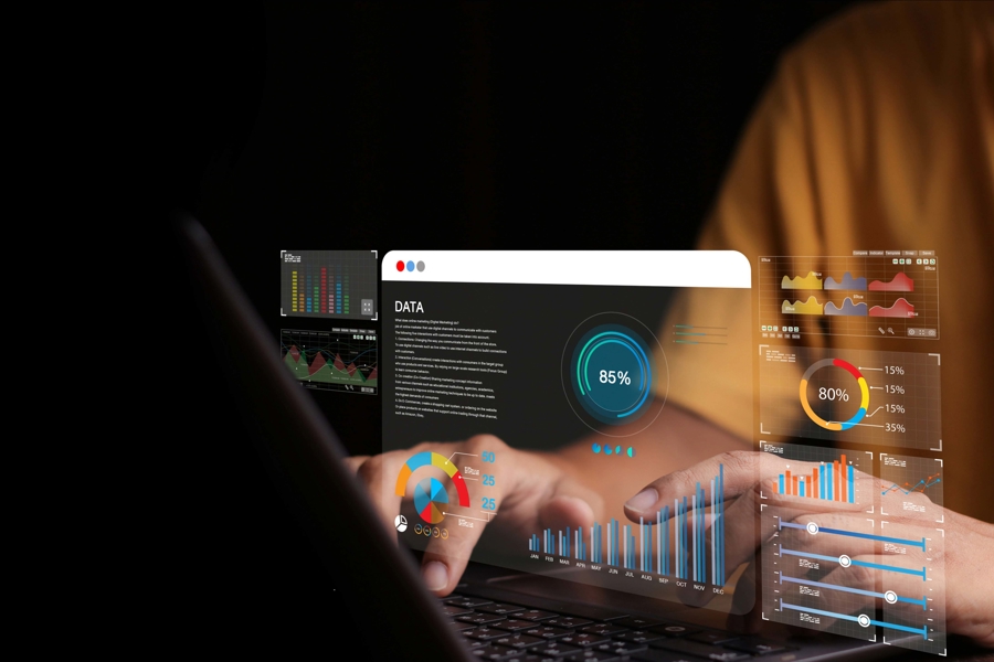 Person arbetar vid laptop med digitala dashboards, grafer och realtidsdata som visualiserar övervakning, analys och säkerhet i IT‑miljö, vilket illustrerar brandvägg som tjänst och skydd av affärssystem