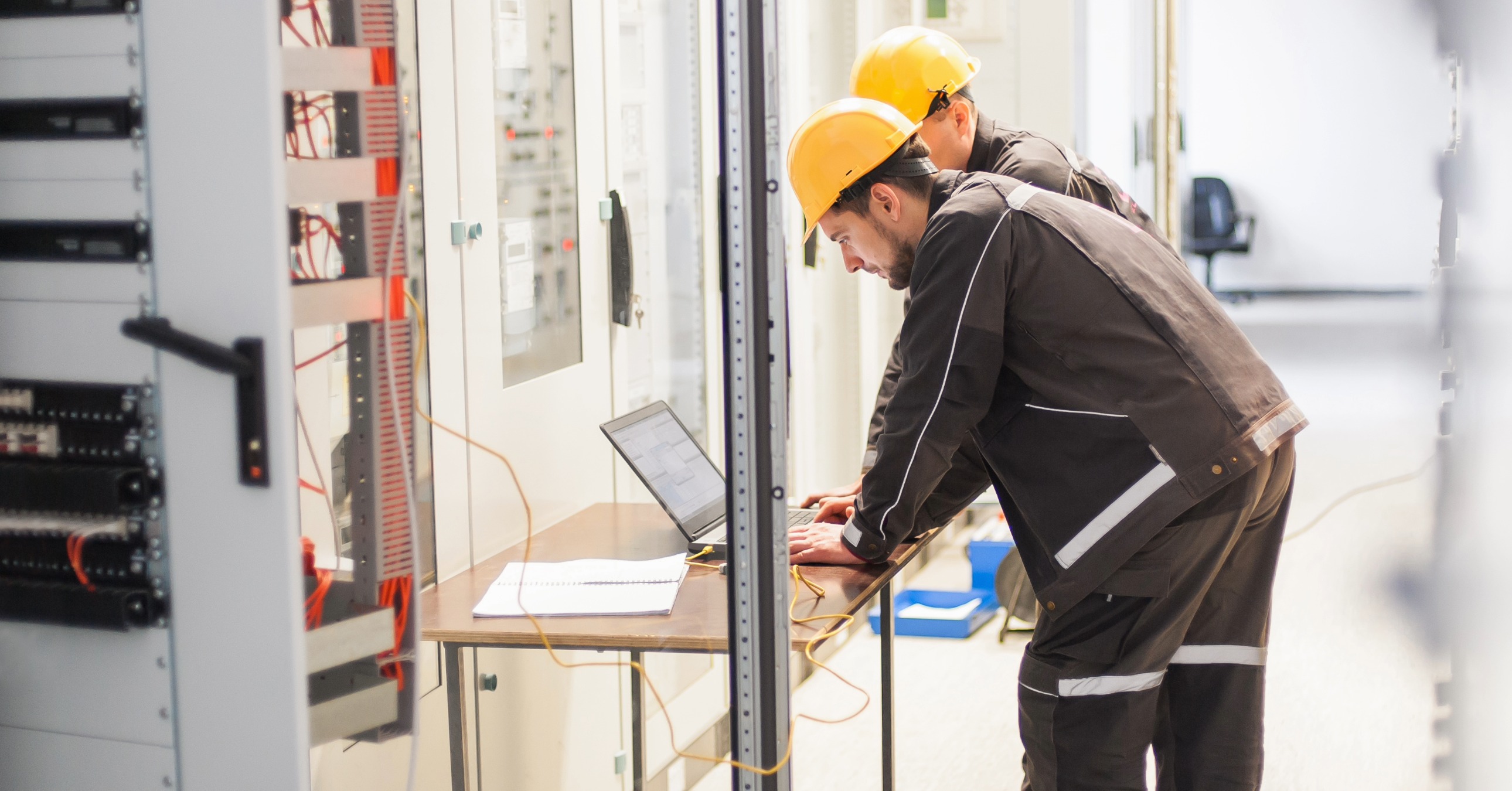 Tekniker Arbetar Vid Elskåp Med Bärbar Dator Under Service Och Felsökning I Industriell Miljö