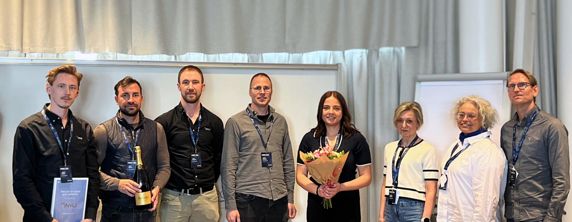Gruppbild från Pyramid-konferens där deltagare uppmärksammas med diplom, blommor och prisutdelning på scen