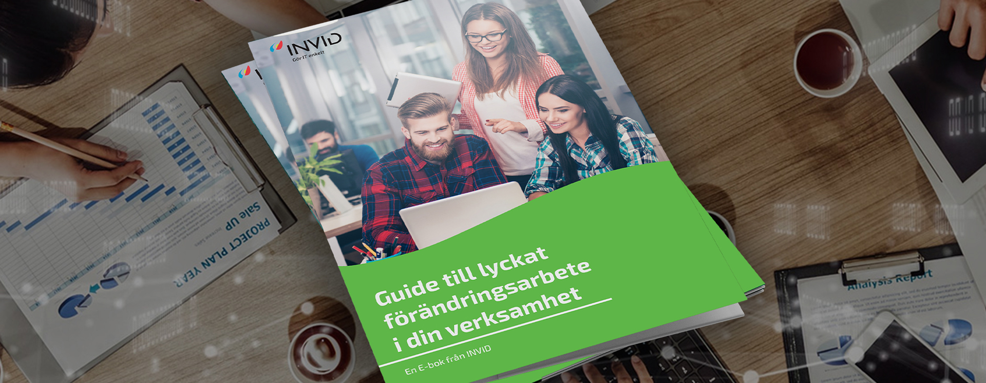 E-bok om förändringsarbete visas ovanpå bord med laptops och dokument