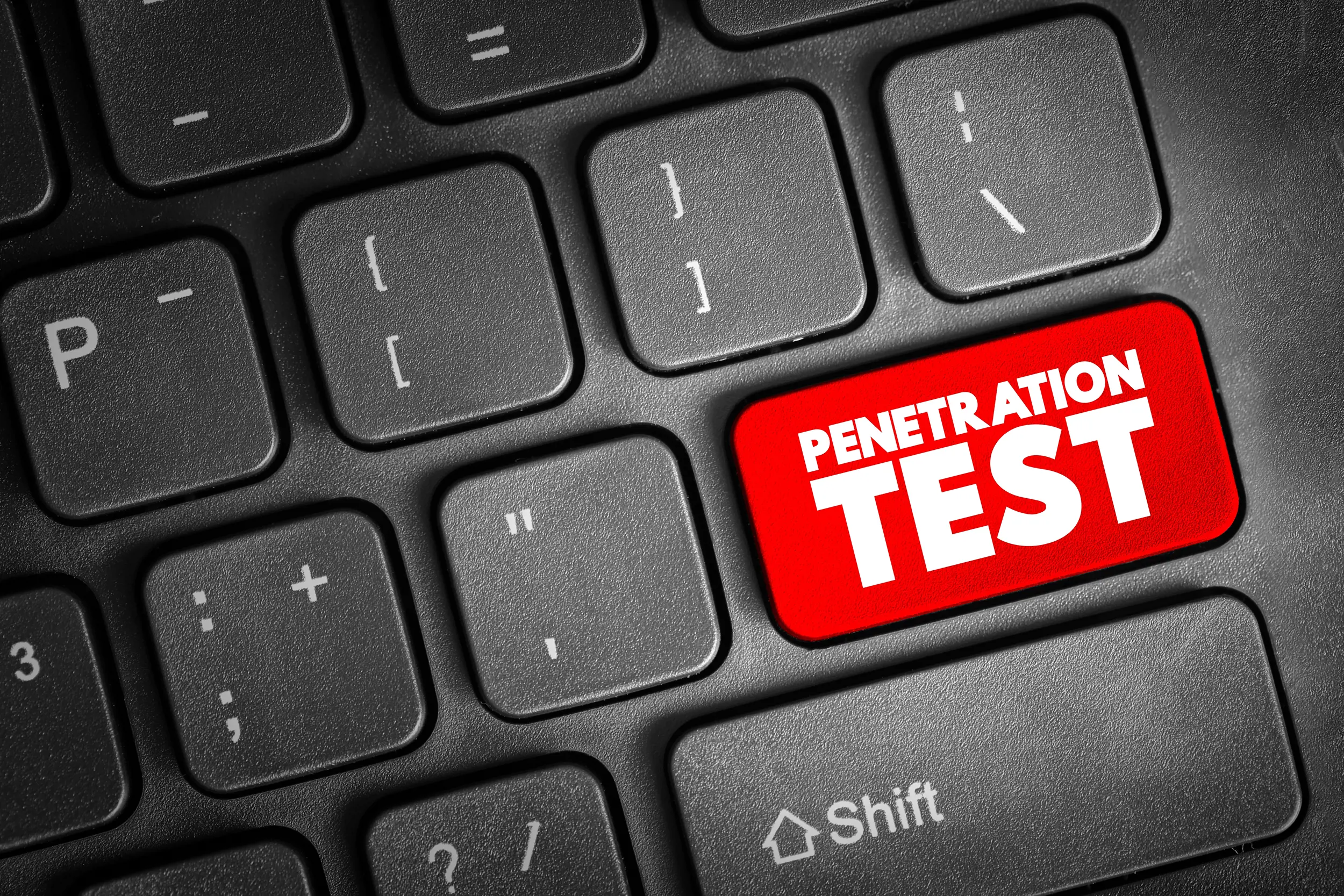 Närbild på svart tangentbord med en tydligt markerad röd knapp med texten “Penetration Test”, vilket illustrerar tester av IT‑säkerhet och sårbarheter i system