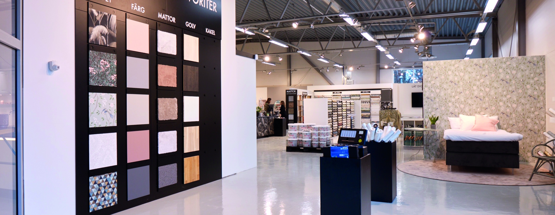 Interiör i Happy Homes-butik med inspirerande utställningar för tapeter, färg, golv, kakel och heminredning i modern butiksmiljö