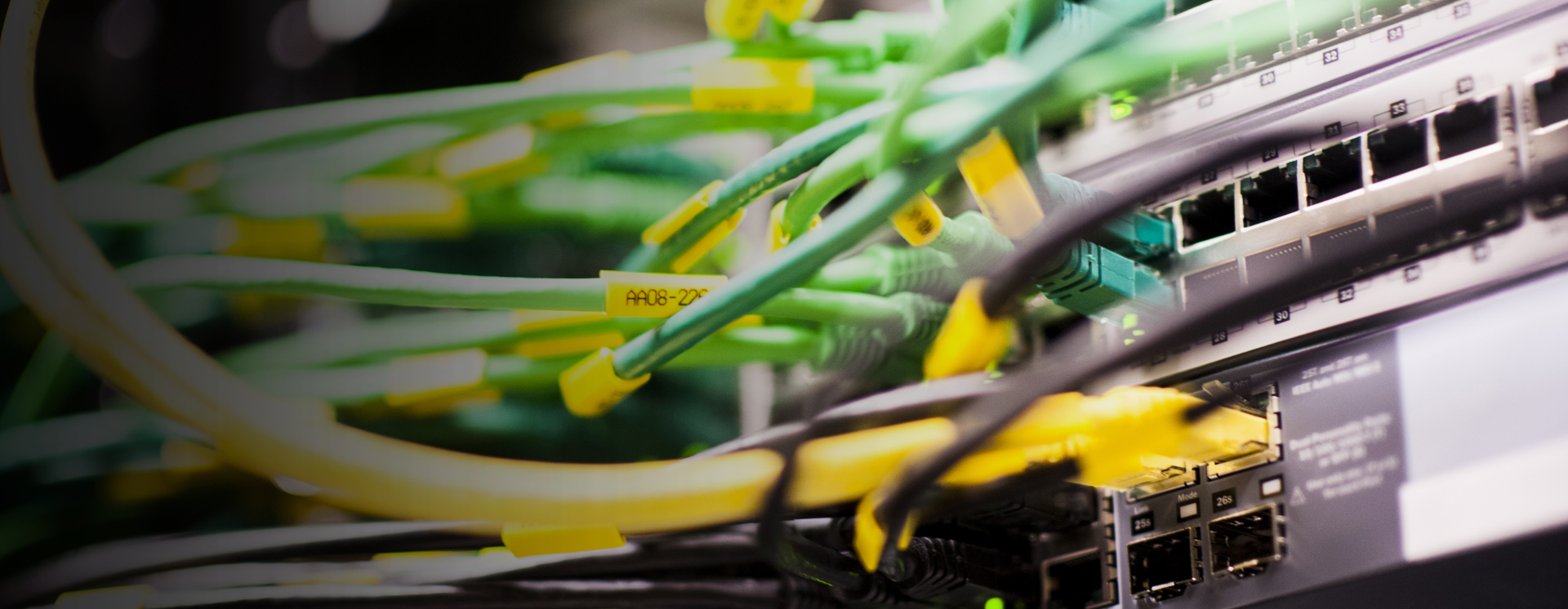 Närbild av nätverksutrustning med anslutna nätverkskablar i switch och patchpanel, vilket visar IT‑infrastruktur, datakommunikation och installation i servermiljö