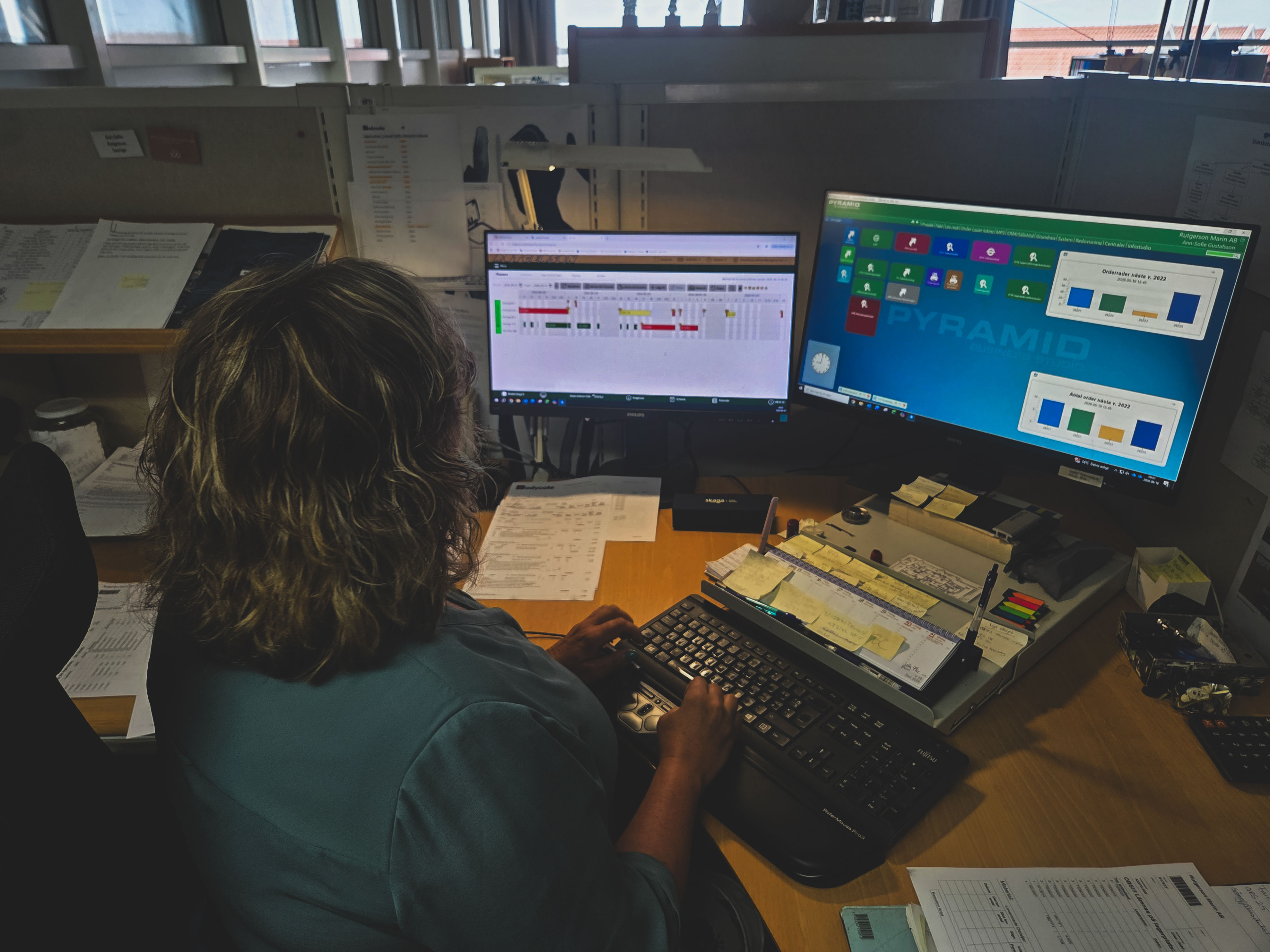 Person Arbetar Vid Flera Datorskärmar I Produktionsmiljö Och Övervakar Affärssystem, Planering Och Verksamhetspr