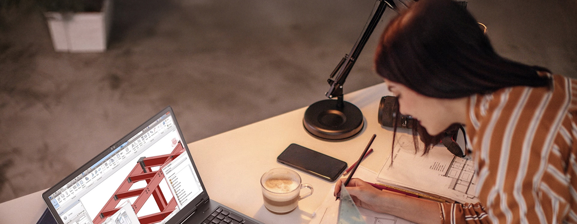 Person arbetar med CAD‑ritning på Lenovo-laptop vid skrivbord, fokus på konstruktion, design och digitala ingenjörsverktyg
