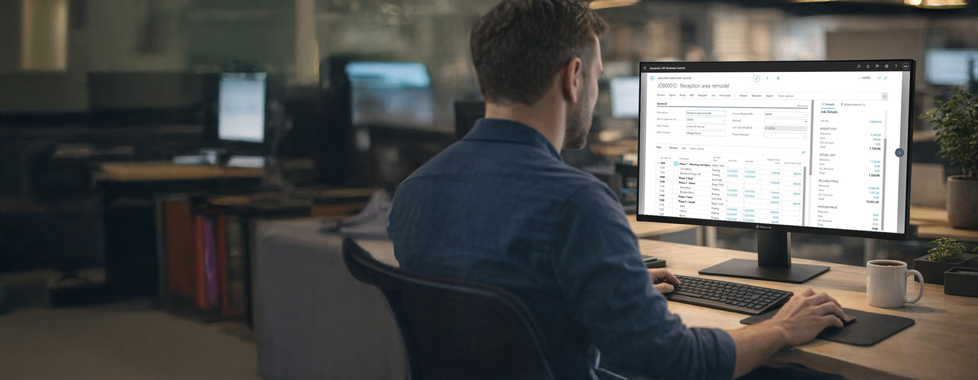 Person arbetar vid dator i modern kontorsmiljö och använder Microsoft Dynamics 365 Business Central för att hantera affärsprocesser, kunddata och ekonomi i digitalt affärssystem