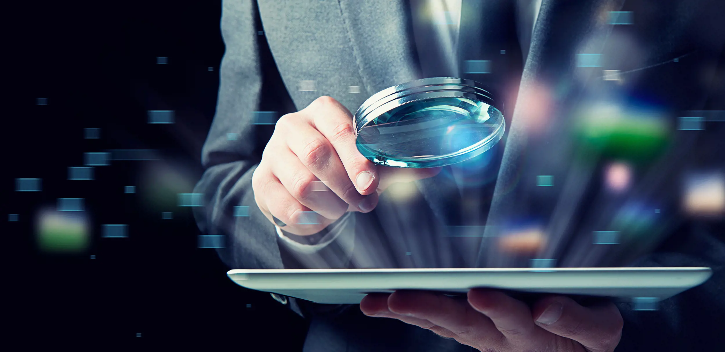 Närbild på en hand som håller ett förstoringsglas över en surfplatta, med överlagrade digitala datapunkter och grafik som symboliserar nulägesanalys, datagranskning och insikt i IT‑miljöer