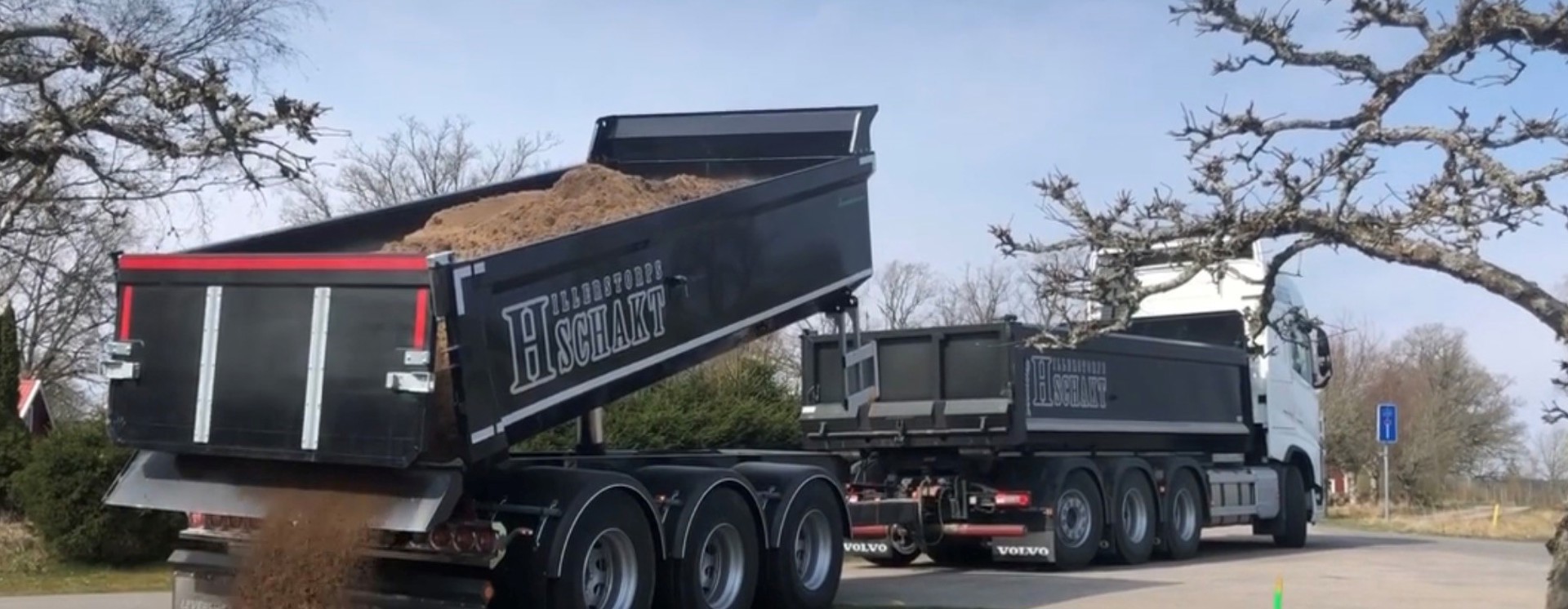 Lastbil från Hillerstorps Schakt tippar grus vid väg- och markarbete med fokus på transport, logistik och anläggningsentreprenad
